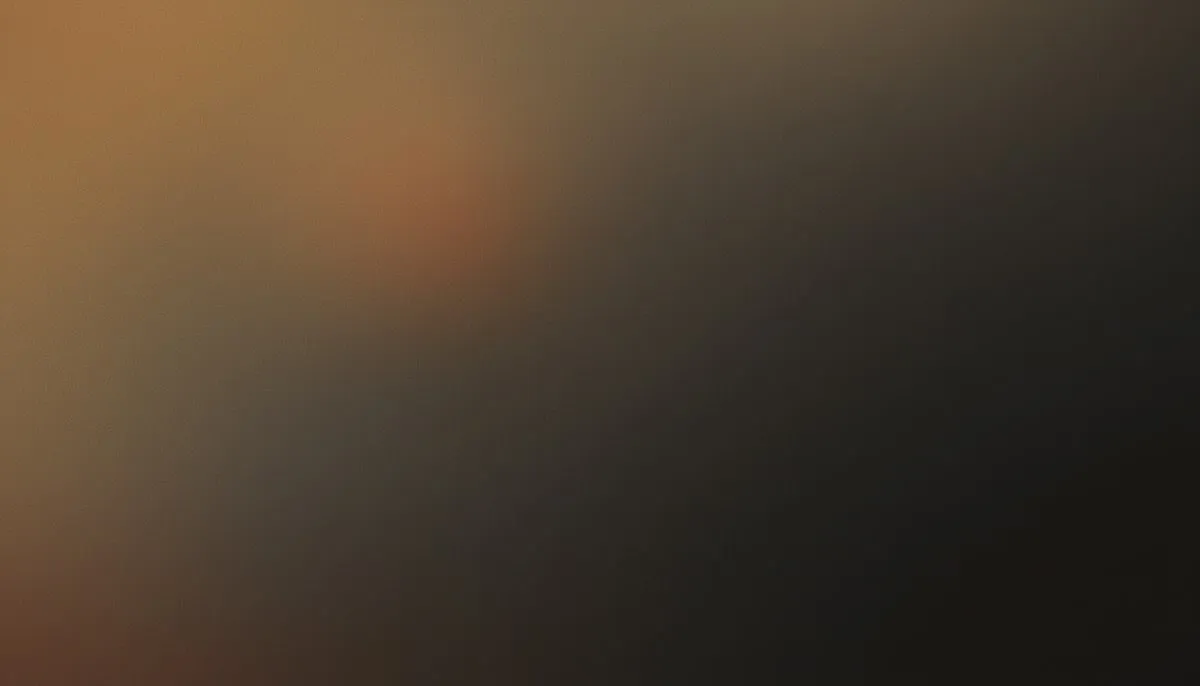 Muted amber warmth drifts from the upper-left into deep charcoal shadow across the right, a faint bloom of desaturated burnt orange dissolving slowly into taupe and dark grey beneath a heavy layer of fine film grain.