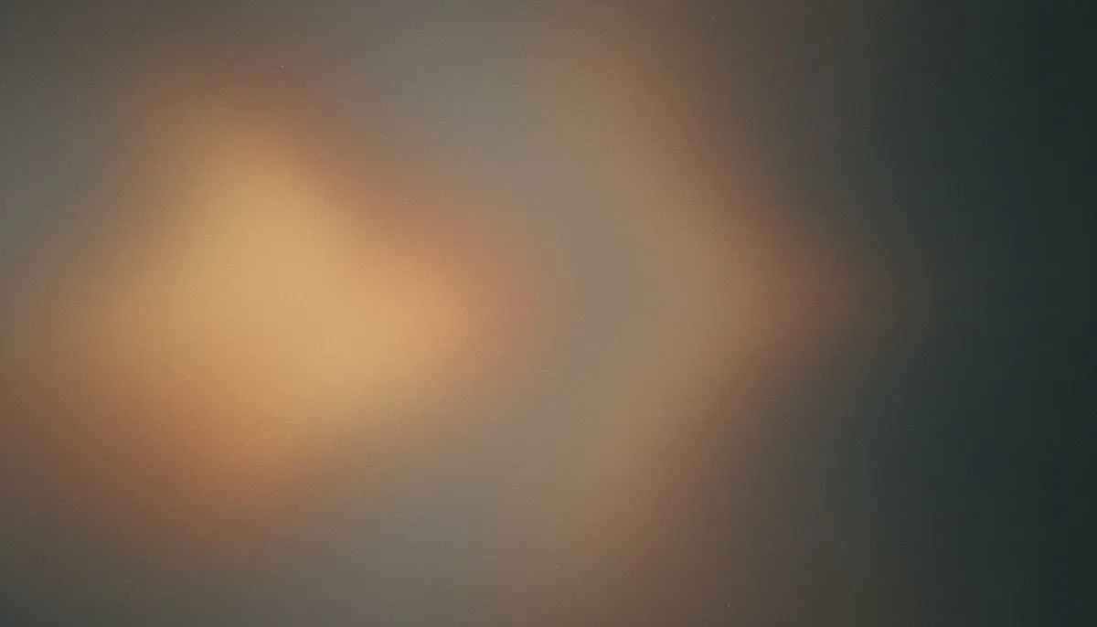 A muted mesh gradient where four soft pools of greyed amber and dusty gold glow at uneven strengths across a dark taupe field, two of them dimming almost to charcoal while two hold their warmth, the whole frame veiled in heavy film grain.