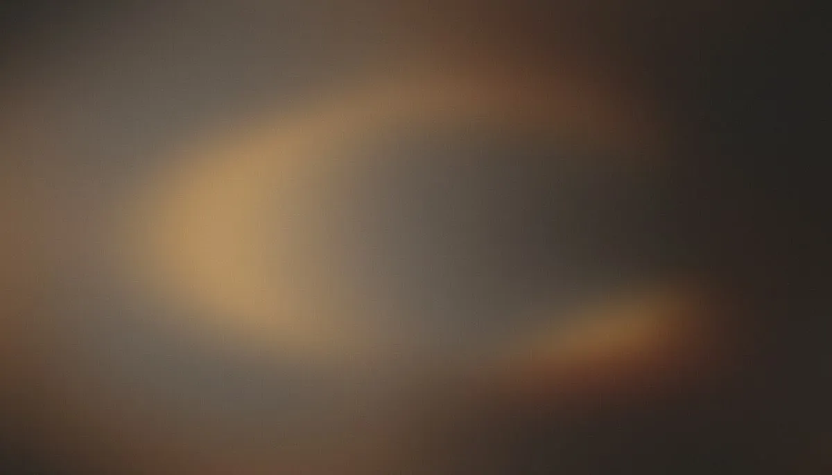A single continuous mesh gradient drifts from grayed amber warmth pooled at the left-center through deep charcoal and taupe, with a faint rust bloom rising quietly from the lower-right, the whole surface unified by heavy analog film grain.